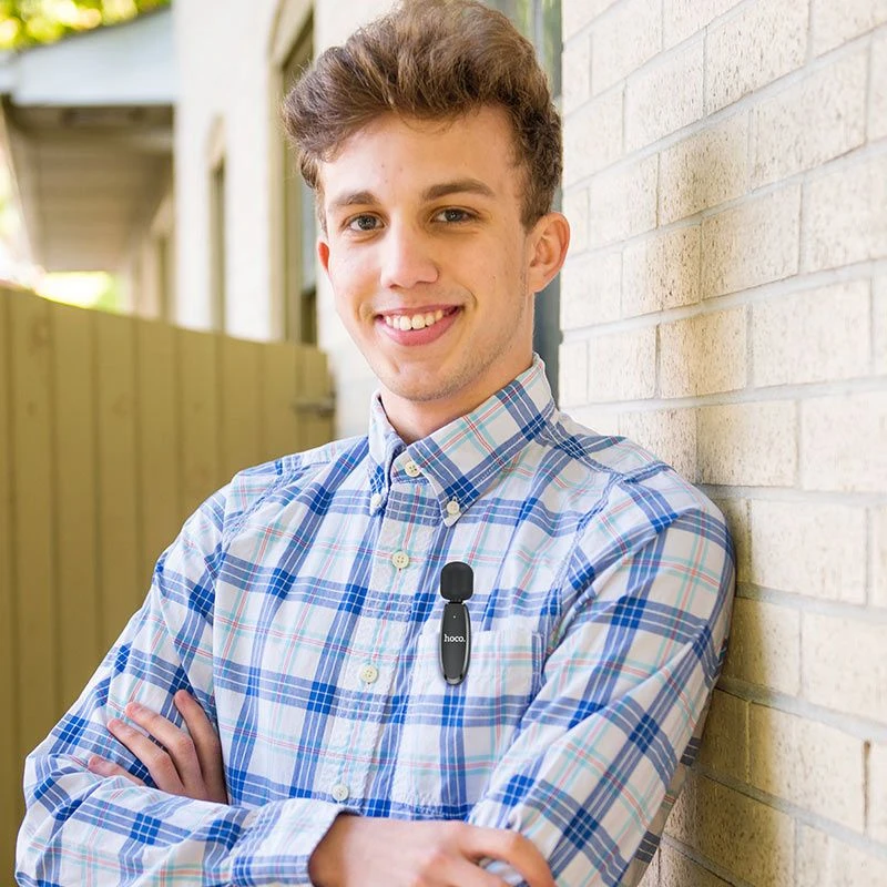 Persona usando el micrófono inalámbrico Hoco L15 con clip de solapa, ideal para grabaciones, entrevistas y videollamadas con sonido claro.