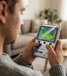 Consola retro portátil Hoco GA40 transparente siendo utilizada en las manos con videojuego pixel art en pantalla