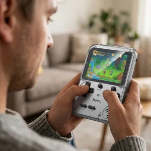 Consola retro portátil Hoco GA40 transparente siendo utilizada en las manos con videojuego pixel art en pantalla